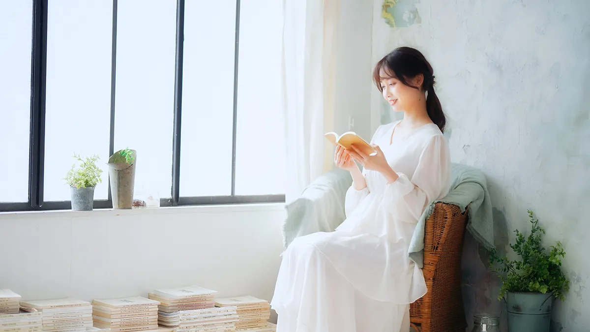 窓辺で本を読む女性